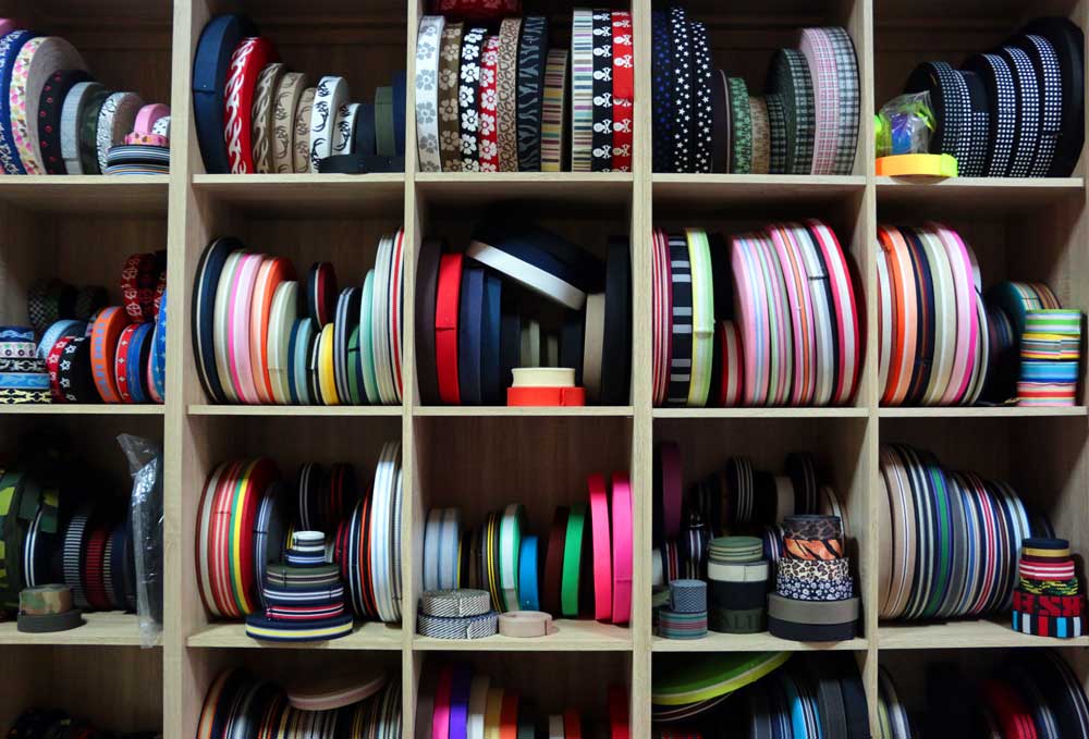 禕尚工廠各色織帶捲料展示，包含多種寬度與配色